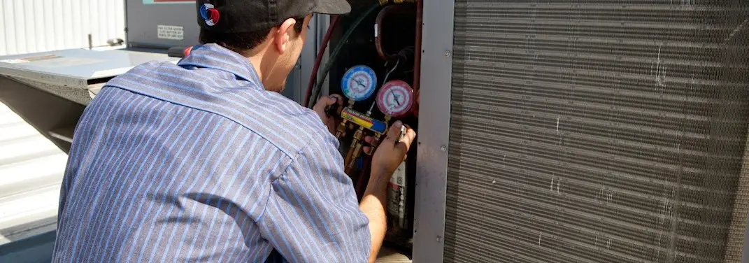 HVAC technician servicing a condenser unit in Ponchatoula
