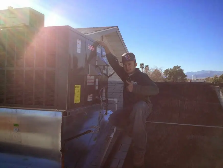 HVAC technician performing AC Tune-Up on a rooftop unit in Ponchatoula